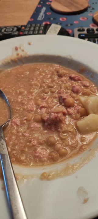 Yellowish gloop in a bowl. Quite a few peas recognizable. Chunks of disintegrated pale meat. (pork). Tastes better than it looks.