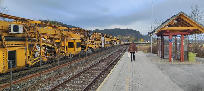 Mysterious machine, yellow and black on a long train. Lots of cars with new ties at the far end. Taken from the platform at Skatval